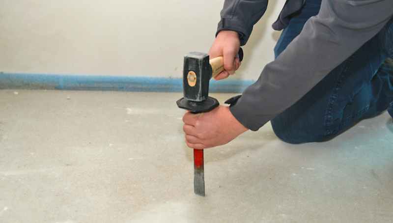Auf der Baustelle wird eine Durchschnittsprobe über den gesamten Querschnitt des Estrichs entnommen. Bild dient lediglich der Veranschaulichung. Beim Meißeln bitte unbedingt Handschuhe tragen.