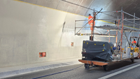 Verarbeiter beschichtet die Tunnelwand auf einem Gerüst