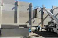 Ein LKW mit Ladekran setzt die vorgefertigten Teile zusammen.