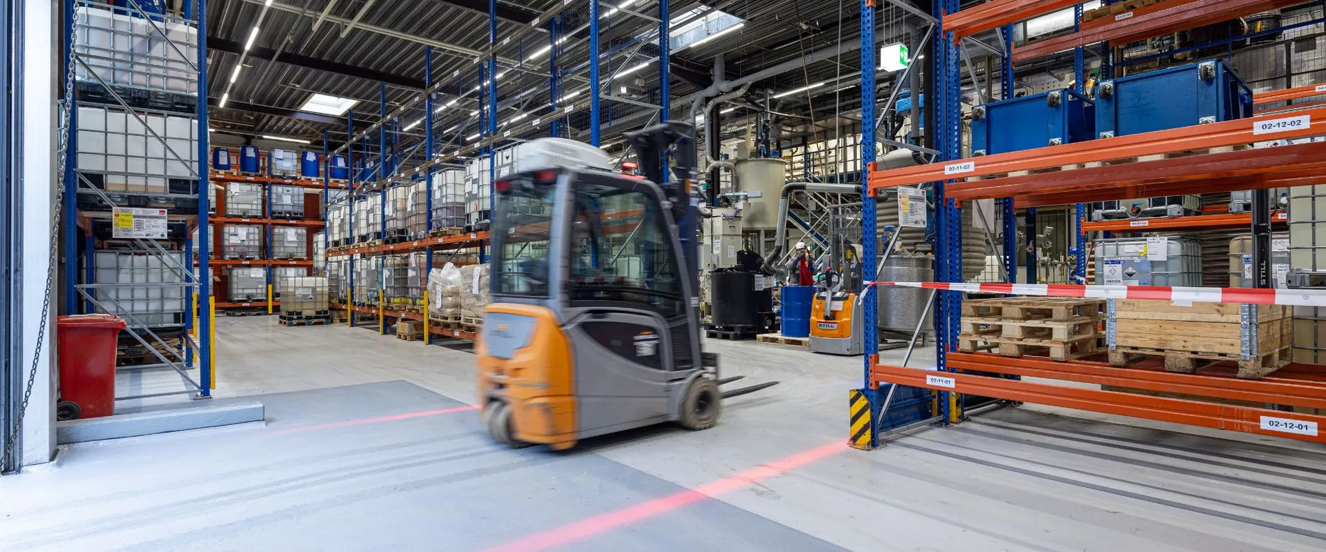 Ein Gabelstapler fährt durch eine Lagerhalle.