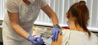 Dr. Stefanie Wiesenhütter, Teil des Impfteams um Dr. Bernd Wiesenhütter, dem Betriebsarzt der MC-Bauchemie, impft eine Ehefrau eines Mitarbeiters der MC-Bauchemie.