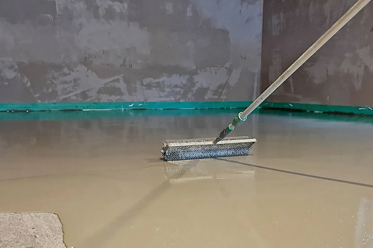 Die frisch beschichtete Bodenfläche wird mit einer Stachelwalze entlüftet. 