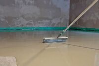 Die frisch beschichtete Bodenfläche wird mit einer Stachelwalze entlüftet. 