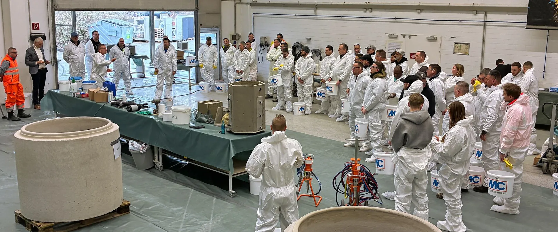 Ein Vortrag wird gehalten, alle Personen tragen weiße Anzüge.