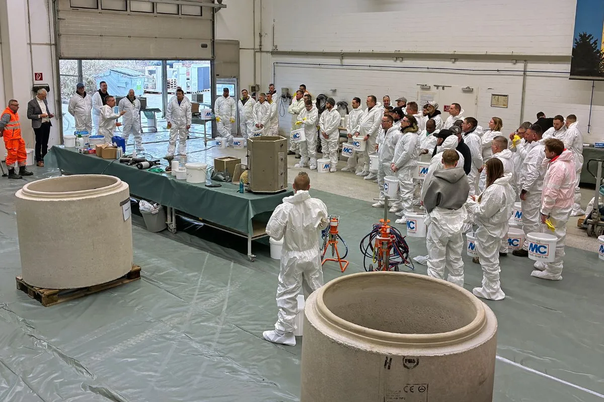 Ein Vortrag wird gehalten, alle Personen tragen weiße Anzüge.