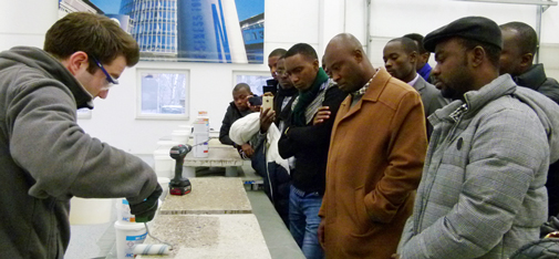 Interessiert folgen die afrikanischen Gäste der Produktdemonstration zu Industriebodenbeschichtungen im MC Veranstaltungs- und Trainingszentrum in der Müllerstraße in Bottrop.